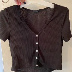 Basic black shirt with white buttons.